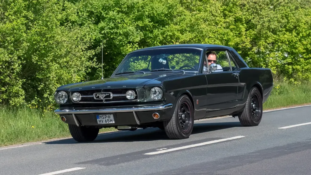 Dark 1965 Ford Mustang GT, first-generation Mustang, on the road