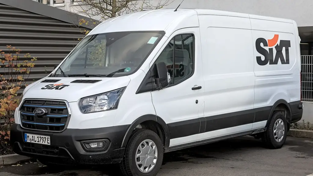 White Ford E-Transit electric van in a rental company livery, photographed in Stuttgart