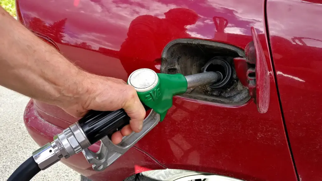 Driver filling a car with gasoline at a fuel pump