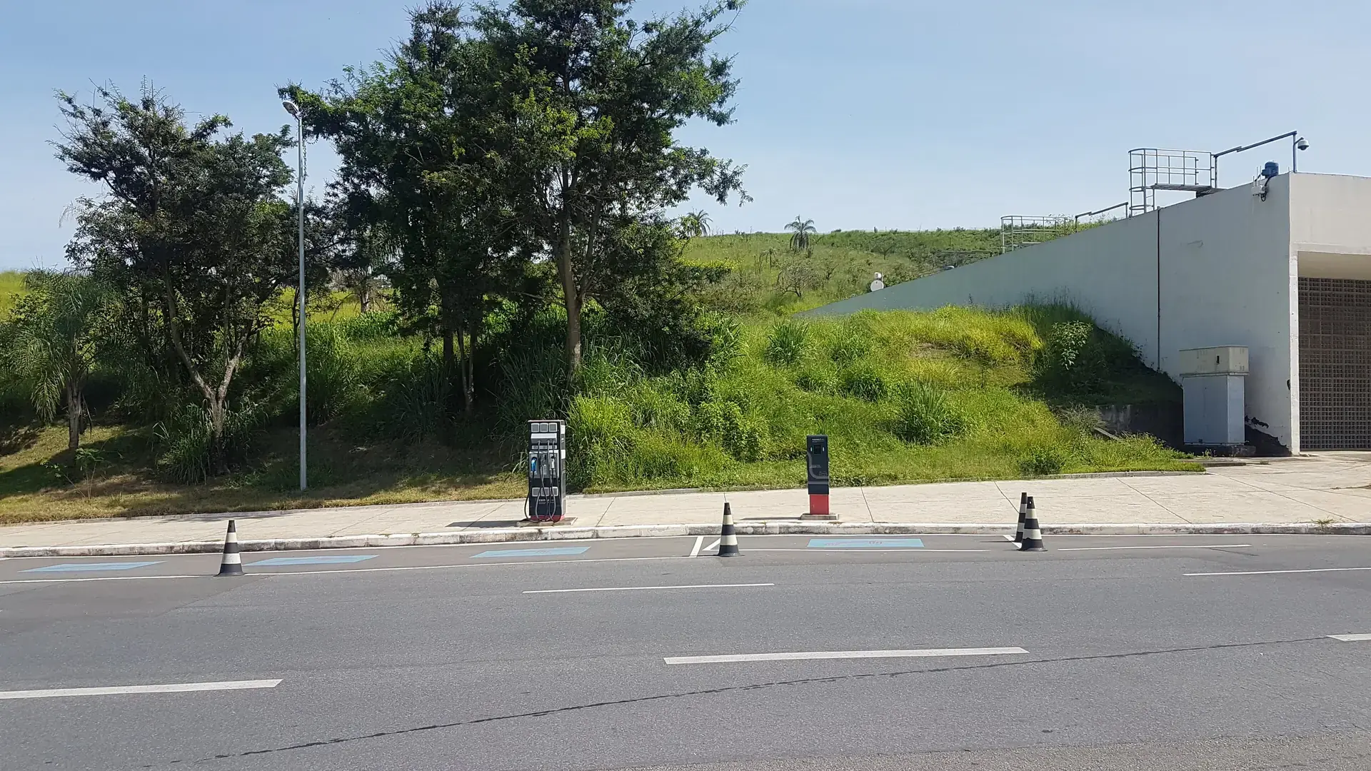 Service station with fuel pumps and electric vehicle chargers side by side