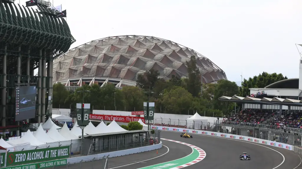 Formula 1 cars passing the Foro Sol stadium section at Autódromo Hermanos Rodríguez in Mexico City