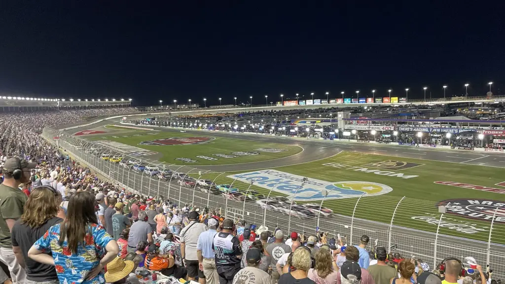 NASCAR Cup cars racing at night during the Coca-Cola 600 at Charlotte Motor Speedway