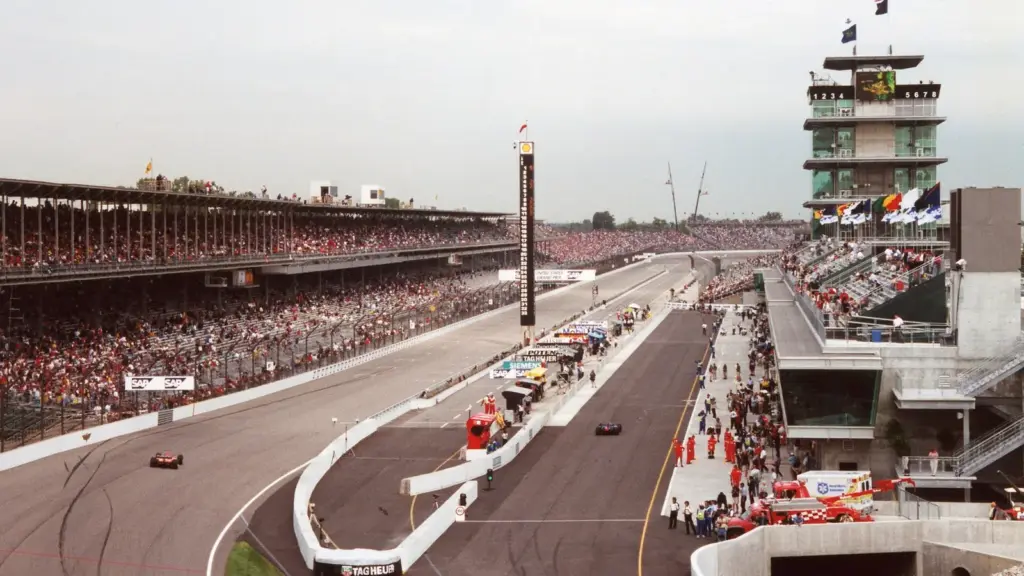 Race cars on the front straight below the Pagoda at Indianapolis Motor Speedway