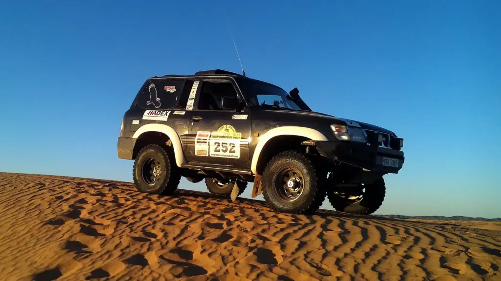 A modified Nissan Patrol rally-raid car on the dunes of the Moroccan desert
