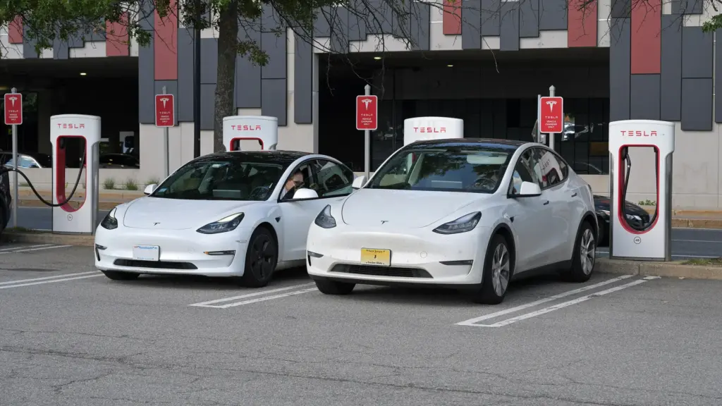 Tesla Model 3 and Model Y charging side by side at a Supercharger station in Framingham, Massachusetts