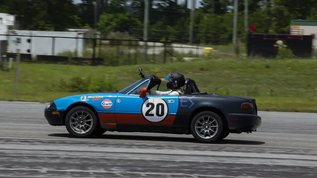 First-generation Mazda Miata driving through the cones at an SCCA autocross