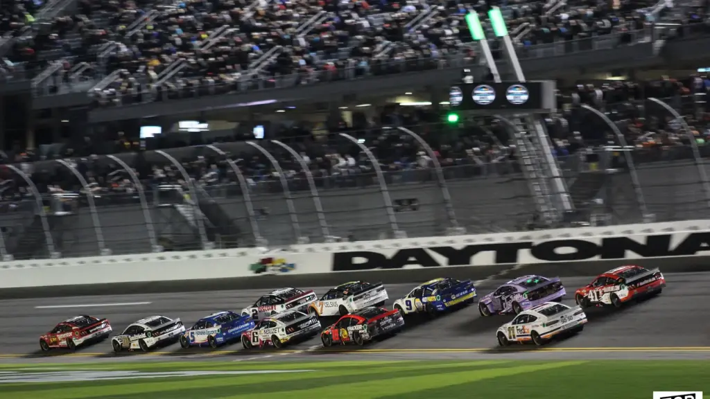 A pack of NASCAR stock cars racing nose to tail
