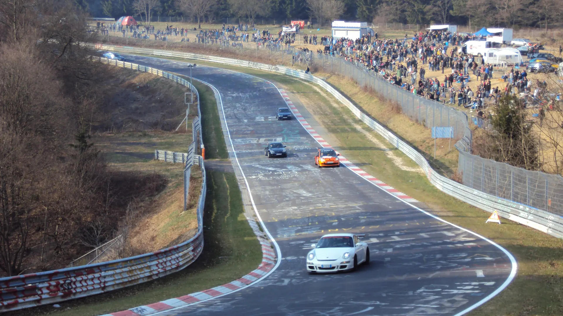 Cars on the Brünnchen section of the Nürburgring Nordschleife, surrounded by the Eifel forest