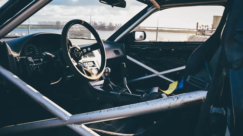Inside a stripped race car: roll cage, racing seat and quick-release steering wheel