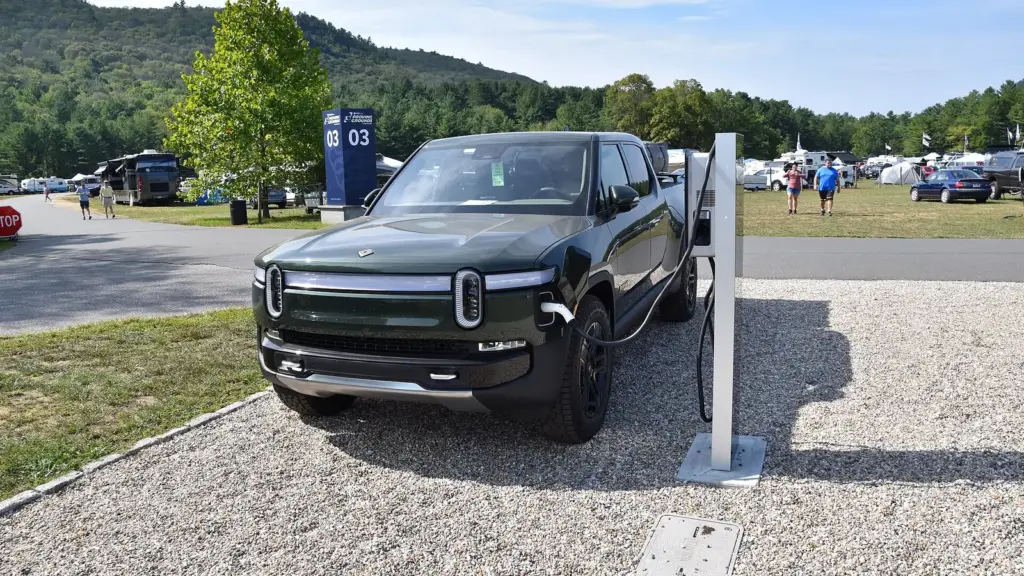 Black Rivian R1T electric pickup at a charging station