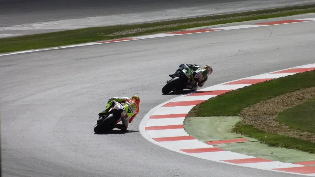 Two MotoGP bikes through Maggotts during practice for the 2013 British motorcycle Grand Prix at Silverstone