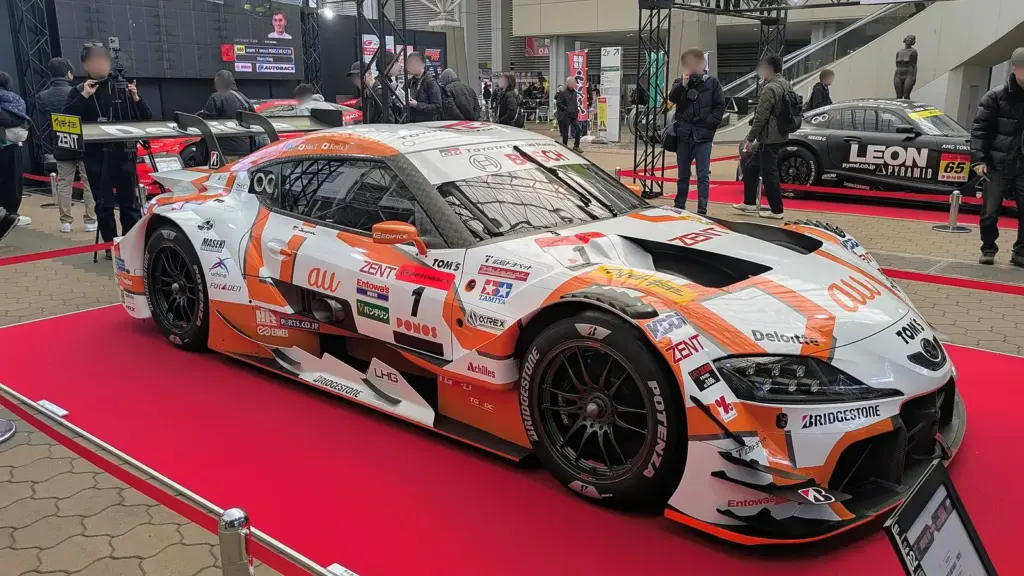 The 2025 GT500 champion au TOM'S Toyota GR Supra on display at Osaka Auto Messe 2026