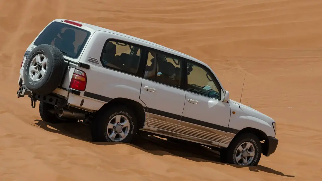 White Toyota Land Cruiser 100 Series climbing a sand dune in the UAE desert