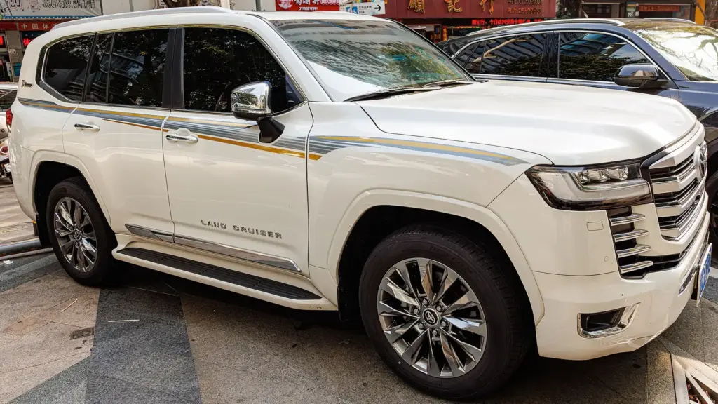 White Toyota Land Cruiser 300 Series parked outside a dealer in China