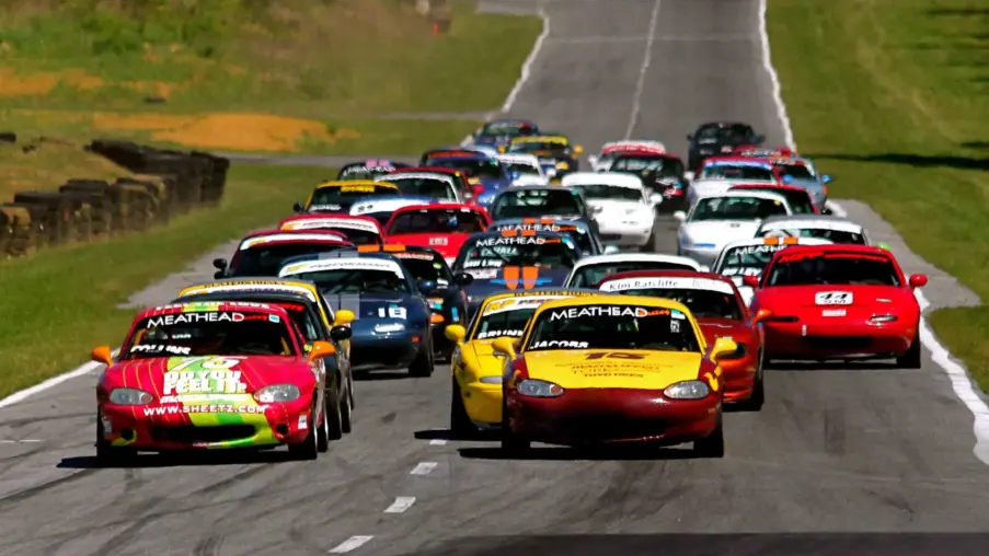 A pack of Spec Miata race cars at the start of an SCCA club race