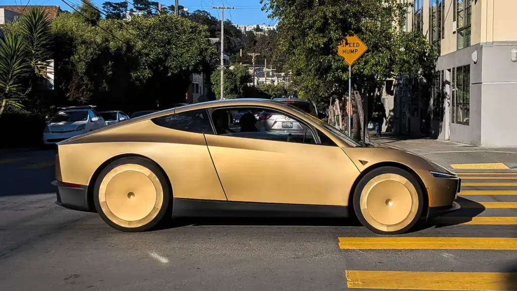 Gold two-seat Tesla Cybercab driving on a San Francisco street
